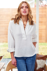 A model wearing the Finley Elsa blouse, a double gauze v-neck cotton white popover blouse with a relaxed fit.