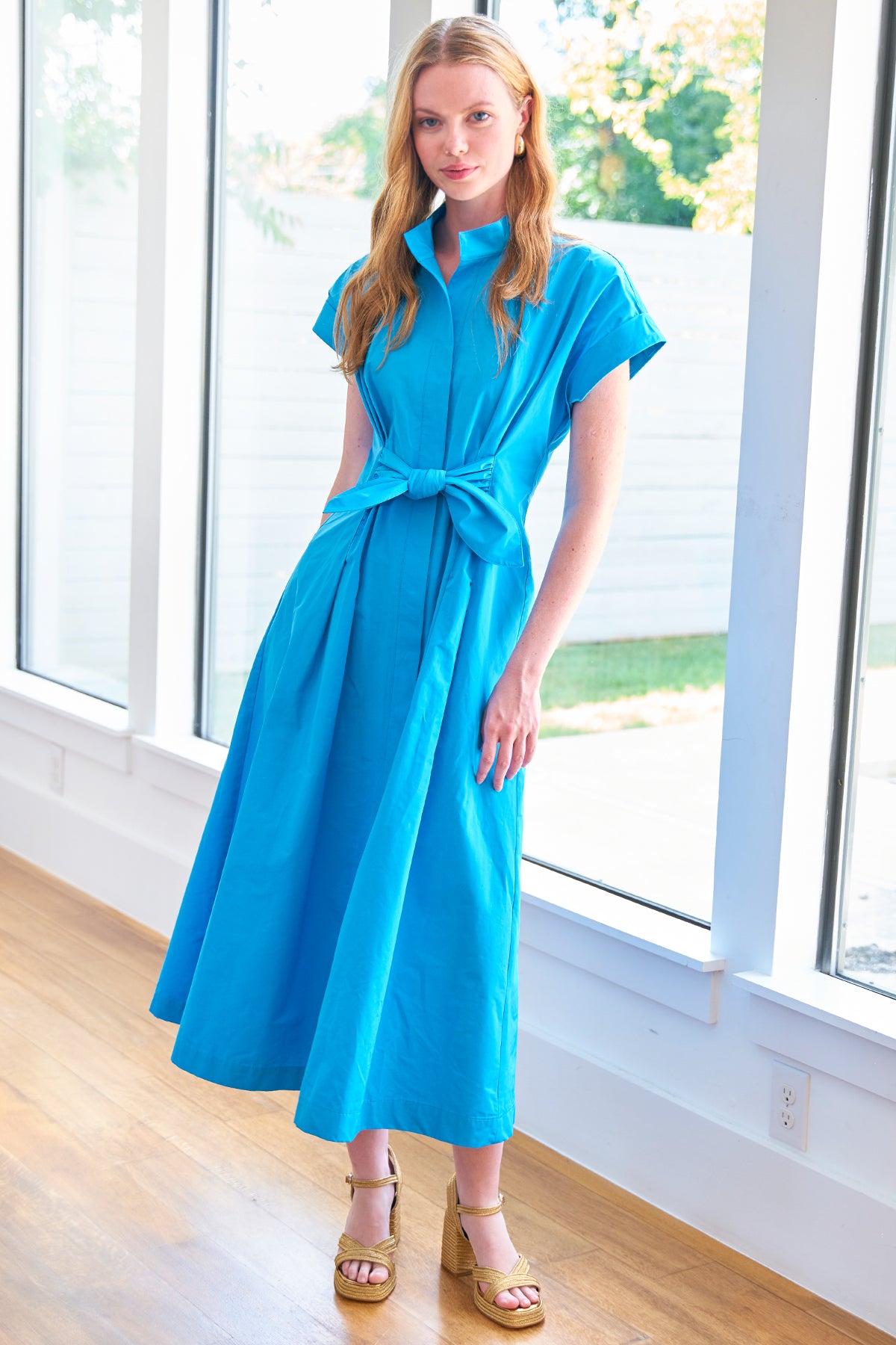 a model front view of the Finley Long Rocky shirt dress with a ruffle waistline, washed linen fabric in turquoise color, and on-seam pockets.
