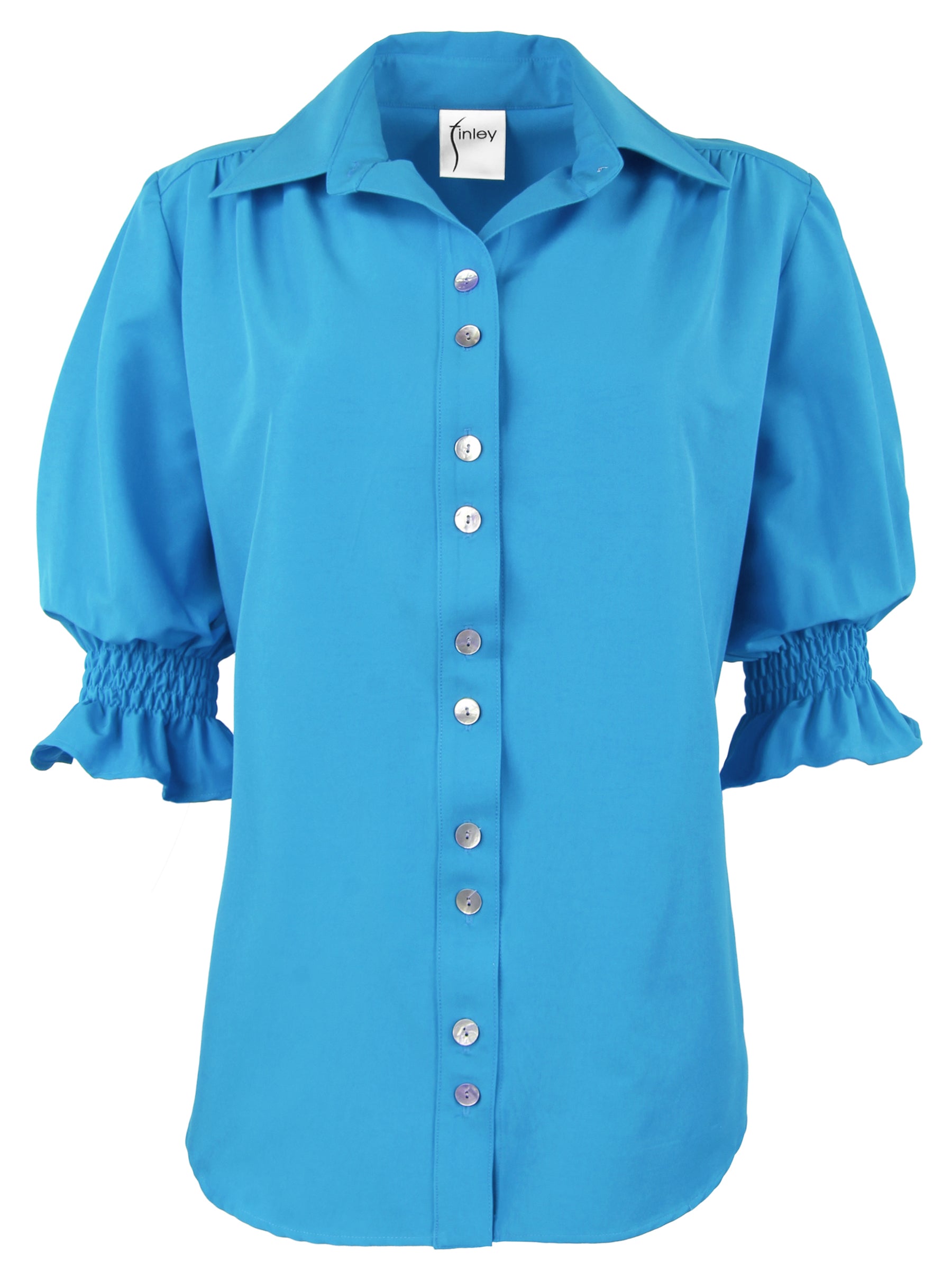 A front view of the Sirena shirt in turquoise, with shirred seams and puffed elbow sleeves.
