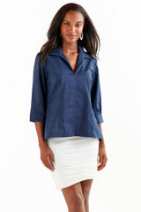 A model wearing the Finley swing shirt, a 3/4 sleeve navy v-neck popover with a relaxed shape and a back inverted pleat.