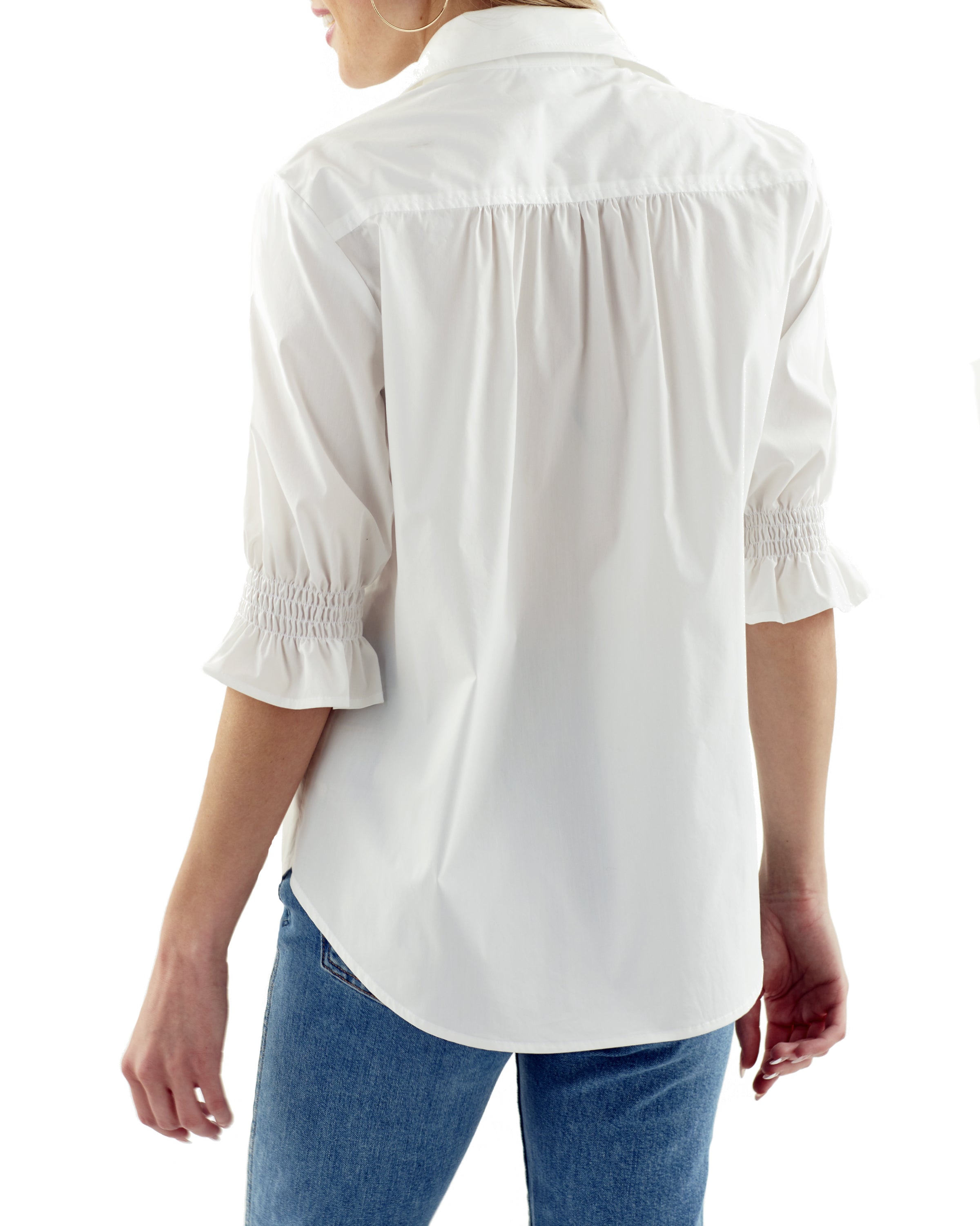 A model wearing the Finley Sirena shirt, a blue and white striped button-down blouse with a puffed sleeve and spread collar.